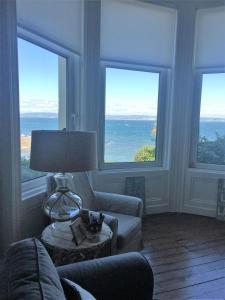 a living room with windows and a lamp on a table at Perfect getaway, seafront home in Bangor +8 photos