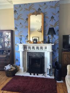 a living room with a fireplace with a mirror at Perfect getaway, seafront home in Bangor