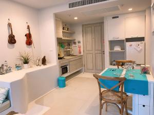 cocina con mesa azul y sillas en Chelona huahin beachfront condominium, en Khao Tao