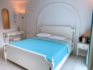 una camera bianca con un letto bianco e due tavoli di Chelona huahin beachfront condominium a Khao Tao