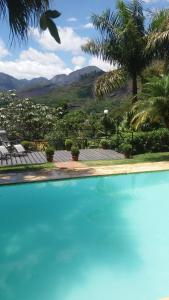 a large blue swimming pool with a view of a city at The Lodge in Teresópolis