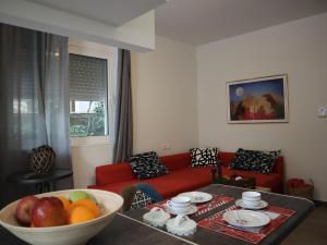 a living room with a red couch and a bowl of fruit at Nefeli in Athens