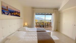 a bedroom with a bed and a large window at La Cala Golf Luxury TownHouse, frontline golf, spectacular views in La Cala de Mijas +31 photos
