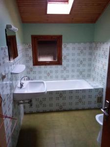 een badkamer met een bad en een wastafel bij Le Fayet d'en haut in Abondance
