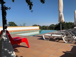 um pátio com cadeiras e um guarda-sol ao lado de uma piscina em Casa do Peso no Crato