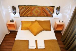 a small bedroom with a bed with yellow pillows at Puerta Real Apartamentos in Seville