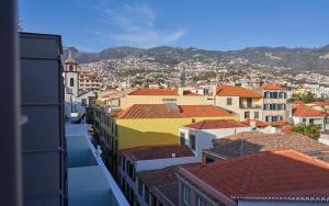 - une vue sur une ville avec des bâtiments et des montagnes dans l'établissement Hotel Cajú, à Funchal
