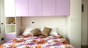 um quarto com uma cama com um cobertor colorido e armários em Marina Beach Blu em Porto Garibaldi