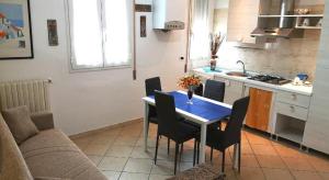 a kitchen with a blue table and chairs in a room at Marina Beach Blu in Porto Garibaldi