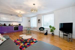 a living room with a couch and a tv at Mulberry Flat 6 - Two bedroom 3rd floor by City Living London in London