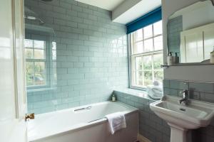 a bathroom with a tub and a sink at The Greyhound Inn in Taunton