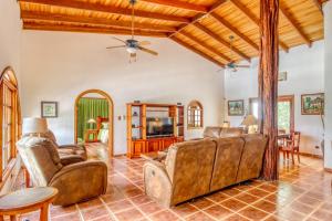 sala de estar con muebles de cuero y ventilador de techo en Casa Margarita, en Playa Flamingo