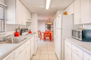 a kitchen with white cabinets and a white refrigerator at Sandy Toes in Mexico Beach