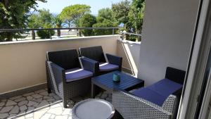 un patio con 2 sillas y una mesa en el balcón en Apartman Katnić by The Beach en Crikvenica