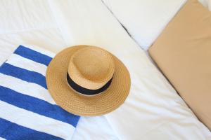 a straw hat is laying on a bed at Mengo Palace Hotel in Rio de Janeiro