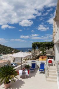 een balkon met stoelen en tafels en uitzicht op de oceaan bij Stuck in the Moment Apartment in Dubrovnik