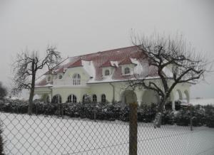 una casa bianca con un tetto rosso dietro una recinzione di Appartement -Villa ROYAL a Oberlauterbach