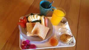a plate with toast and fruit and a glass of orange juice at Sunlight House in Faro
