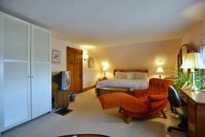 a bedroom with a bed and a desk and a chair at 10th Avenue Guest House & Suites in Hanover