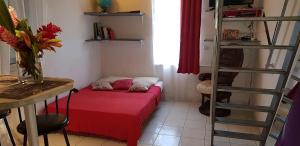 een kleine kamer met een rood bed en een ladder bij SaS NEMO in Lamentin