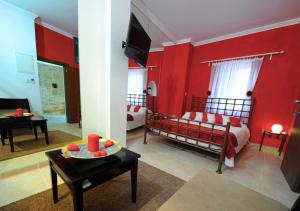 a room with two beds and a red wall at Esperando in Maroni