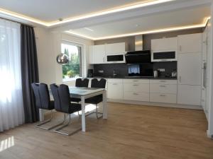 a kitchen and dining room with a table and chairs at Heykens Golfhuus Albatros in Wiesmoor
