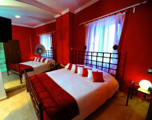 a bedroom with red walls and a bed with red pillows at Esperando in Maroni +35 photos