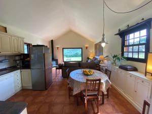 eine Küche und ein Wohnzimmer mit einem Tisch und einem Sofa in der Unterkunft Casa Rural CaChispita in Teror