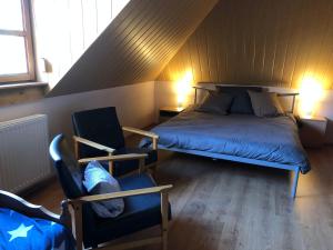 1 dormitorio con 1 cama y 1 silla en el ático en Panzió Rust in Lànycsòk, en Lánycsók