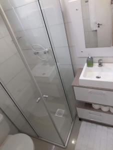 a glass shower in a bathroom with a sink at AP próximo rua gastronômica in Bento Gonçalves