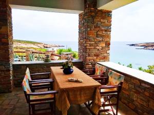Una mesa y sillas en un patio con vista al mar. en Villa Ateni, en Gavrion 42 fotos más