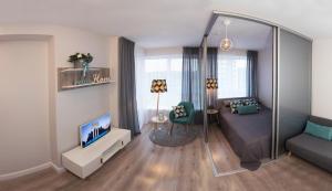 uma sala de estar com uma cama e uma televisão em Relax apartments near Egle em Druskininkai