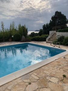 einen Pool mit blauem Wasser im Hof in der Unterkunft Villa KATHERINA G in Schinias