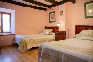 um quarto com 2 camas e uma janela em Casa Navarlaz S N em Valcarlos