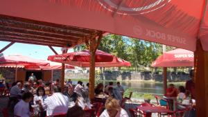 a group of people sitting at tables under red umbrellas at Casa Lerryn in Sertã