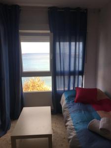 una camera con letto, tavolo e finestra di Estudio frente al mar a Ceuta