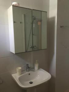 uma casa de banho com um lavatório e um espelho em Estudio frente al mar em Ceuta