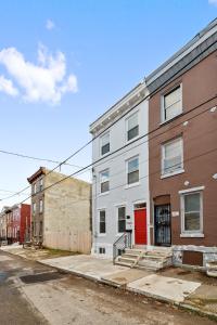 un edificio de apartamentos en una calle con una puerta roja en Luxury Rooms near Temple U, Drexel, UPenn, and the MET, en Filadelfia