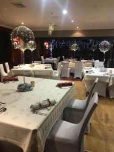 a dining room with white tables and white chairs at Chieftain Hotel in Inverness