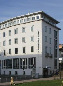 a white building with a sign on the side of it at Stadthotel Kassel in Kassel