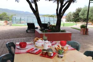 a wooden table with plates of food on it at LA BASTIDE DE NINI in Carcès