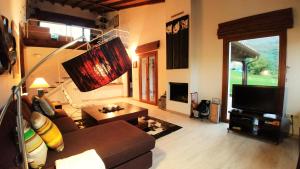 a living room with a couch and a television at La Calma de Llanes in Llanes