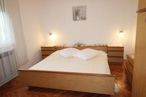 een slaapkamer met een bed met 2 kussens erop bij Apartman Barbara in Ližnjan