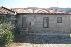 een stenen gebouw met een deur en een raam bij Carneiro Country Houses Casa do Avô in Carneiro