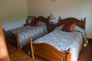 - une chambre avec 2 lits et une lampe sur du parquet dans l'établissement Carneiro Country Houses Casa do Avô, à Carneiro