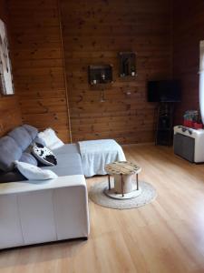 een woonkamer met een witte bank en een tafel bij chalet "le Refuge du Brabant" in Cornimont