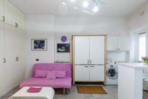a living room with a purple couch and a washing machine at Kibilù - My Lake Arona - vicinanze Stazione e Lago Maggiore in Arona