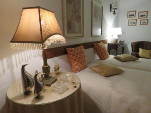1 dormitorio con 1 cama con lámpara en una mesa en Casa do Quintalão, en Raposeira