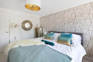 Un dormitorio con una cama grande con almohadas. en The Spacious Gem House Kent with Parking, en Gillingham