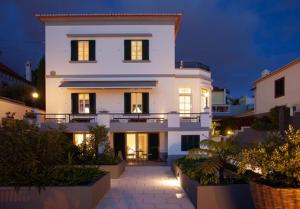 een groot wit huis met lichten aan bij Quinta B. in Funchal